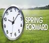 A school clock in a green field saying Spring Foreward.